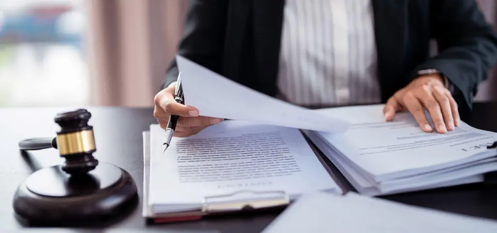 A lawyer reviewing legal documents at a desk, with a gavel in the foreground, emphasizing the legal profession and paperwork.